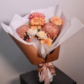 Bouquet of brown and yellow rose flowers wrapped in brown paper with a white ribbon. Designed for brown gown for university graduation ceremonies, perfect graduation gift by Hanaya Flora, based in Sydney.