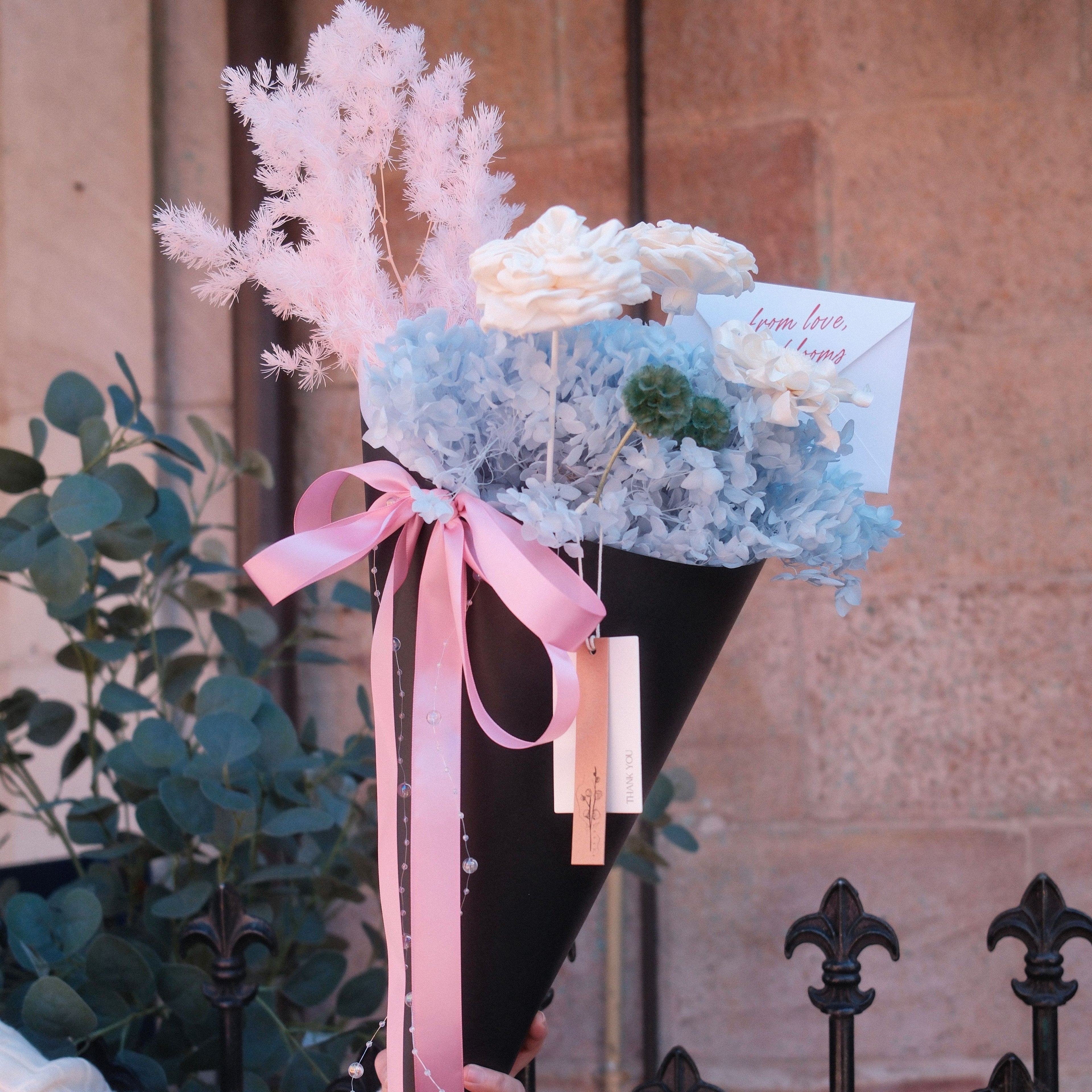 Close-up of Blue Sorbet bouquet featuring preserved hydrangea, pink plume and green thistle detail, Hanaya Flora