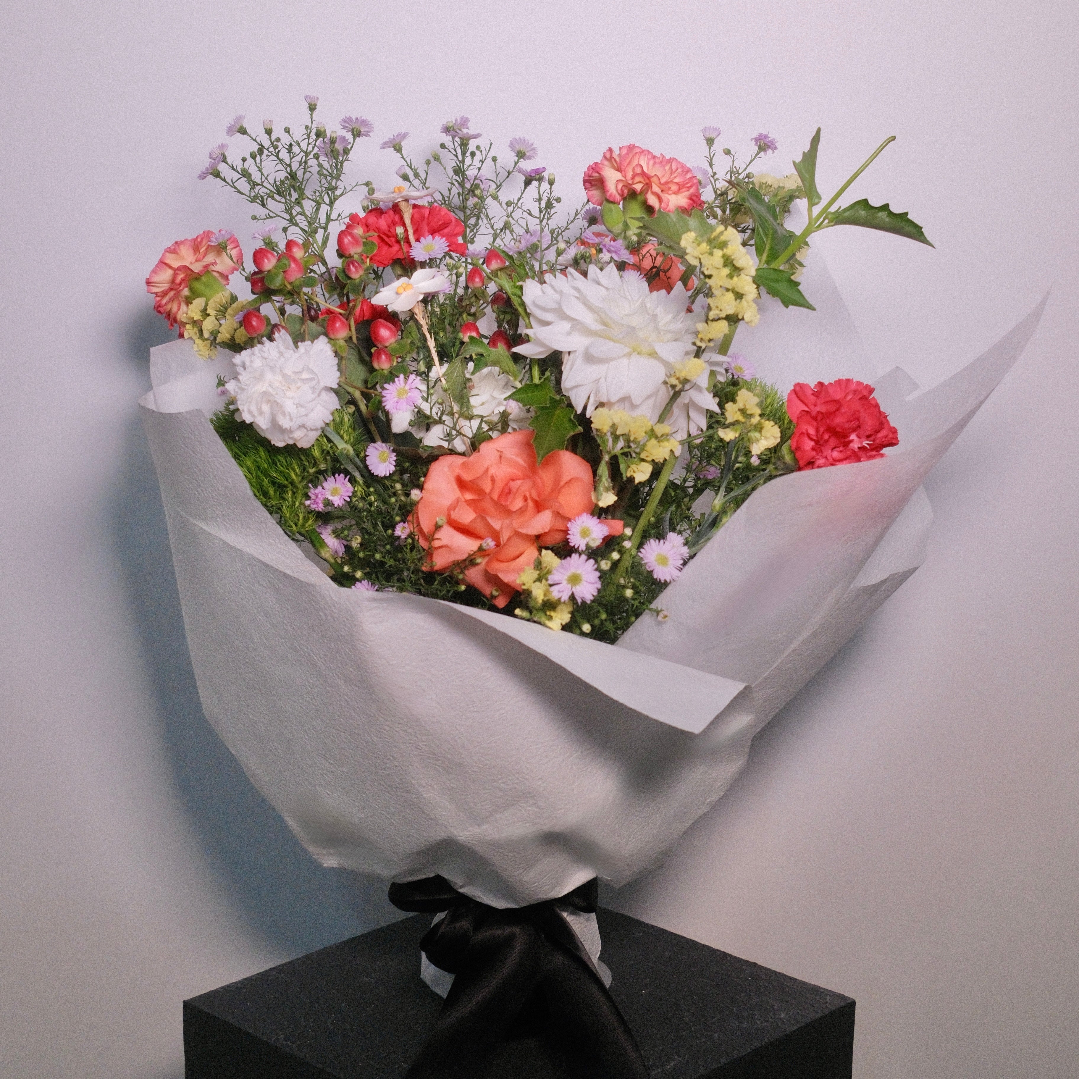 Bouquet of flowers: roses, dahlia, daisy wrapped in white paper buy Hanaya Flora.