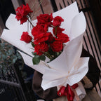 Florist holding the Crimson Kiss red rose bouquet, a romantic gift, Sydney
