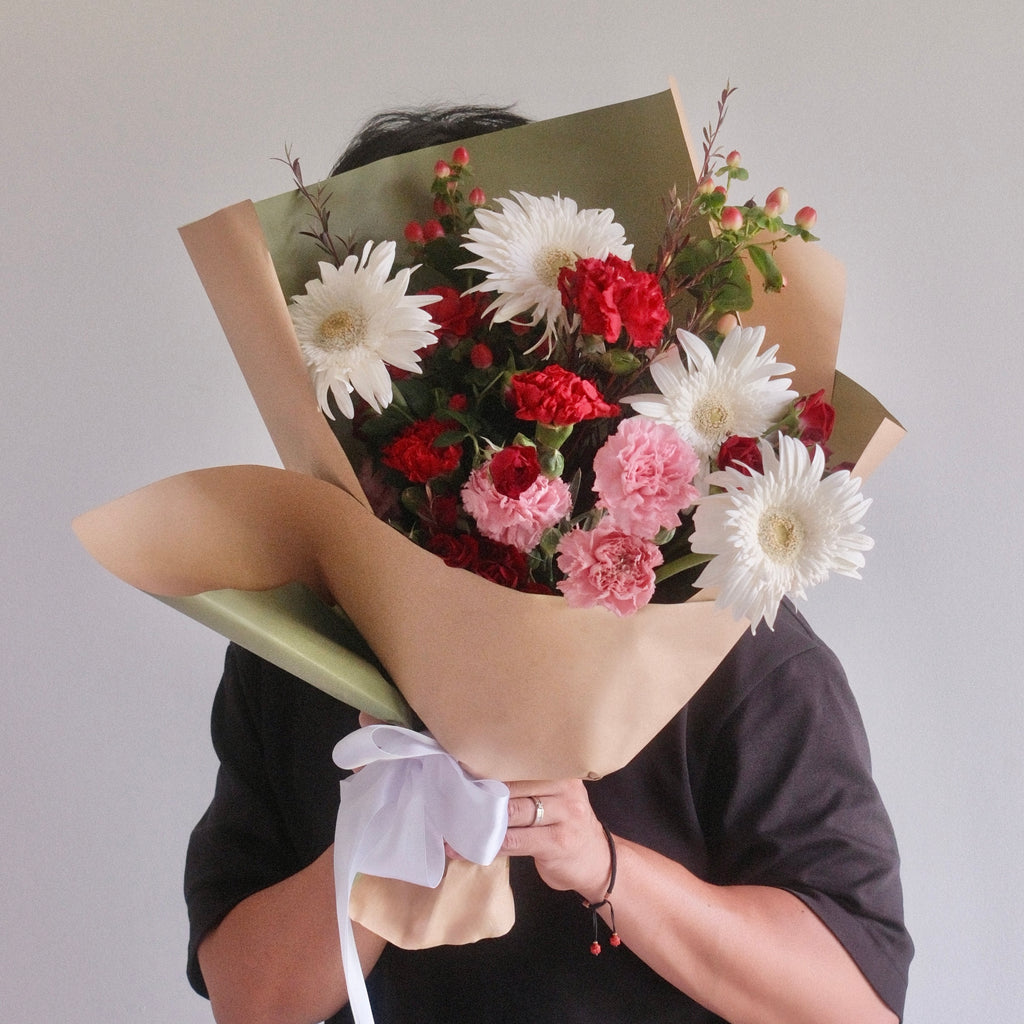 Bouquet of flowers wrapped in green paper with a white ribbon, red rose, red flower, gerbera by Hanaya Flora, Sydney, Surry Hills.