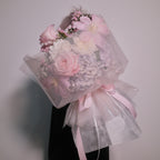 Close-up of the First Love bouquet in translucent wrap, held by a florist