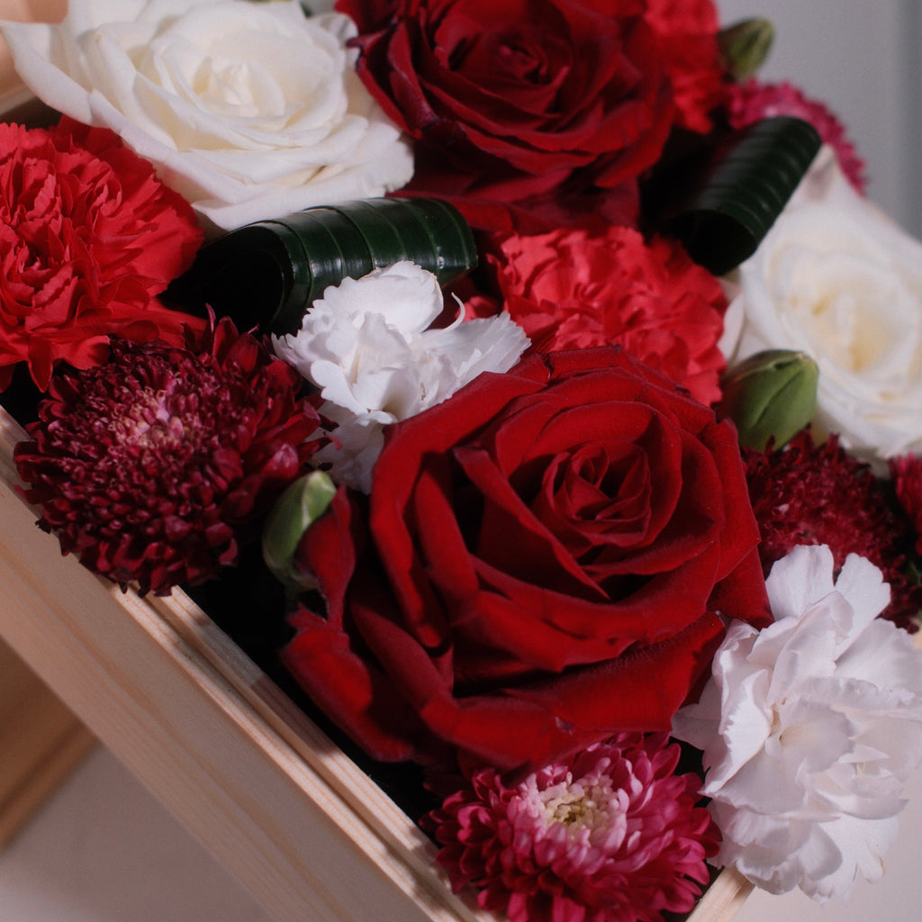 Close-up of the Hanaya Box Red (W) with red and white roses in a wooden box