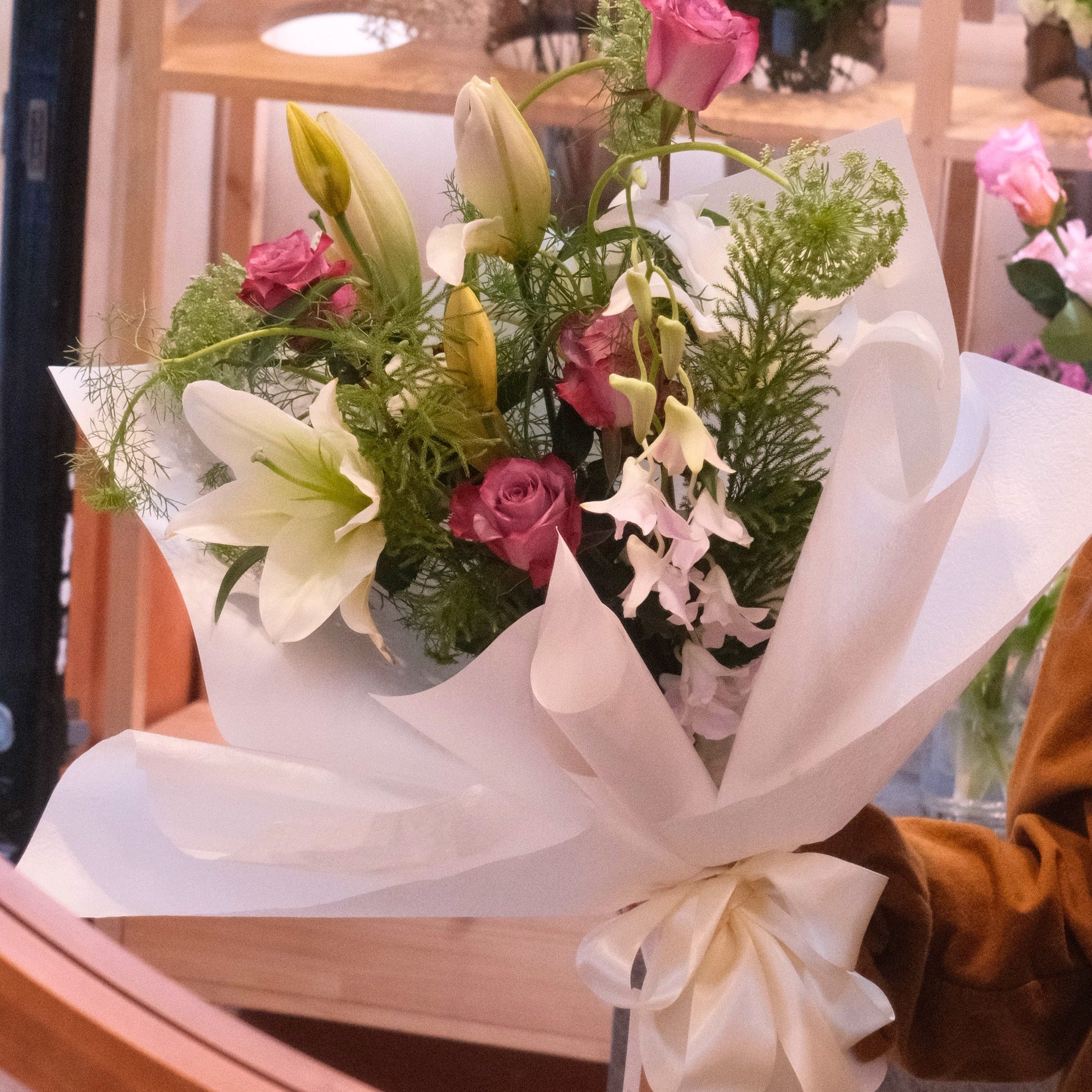 Yasashii Grace bouquet of roses, lilies and orchid wrapped in white paper with a bow, Hanaya Flora Surry Hills
