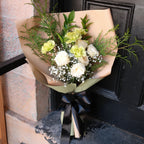 Side angle of the Gentle Remembrance white and sage sympathy bouquet tied with black satin ribbon