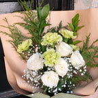 Close-up of white roses, sage green carnations and baby's breath in the Gentle Remembrance sympathy bouquet