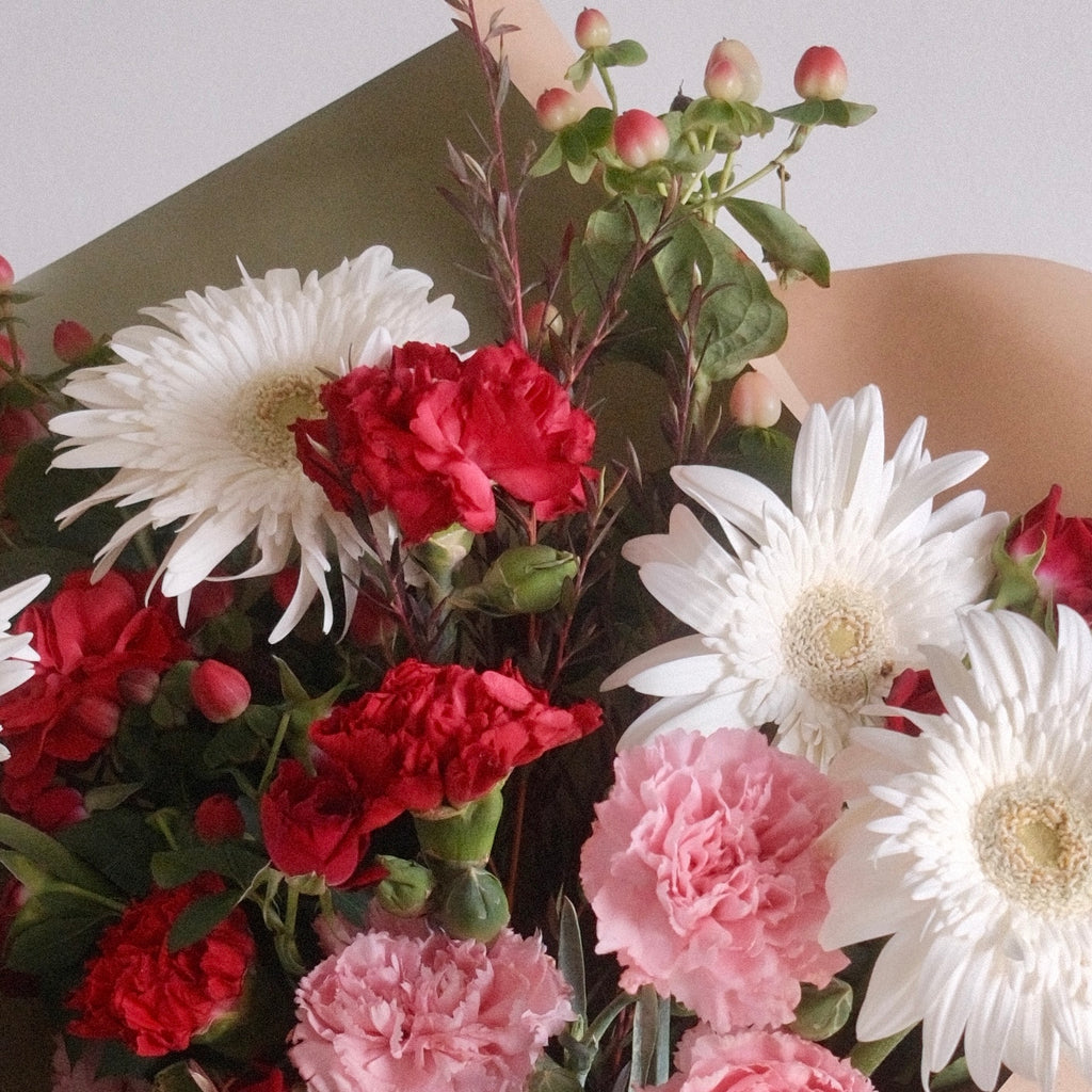 Bouquet of flowers wrapped in green paper with a white ribbon, red rose, red flower, gerbera by Hanaya Flora, Sydney, Surry Hills.
