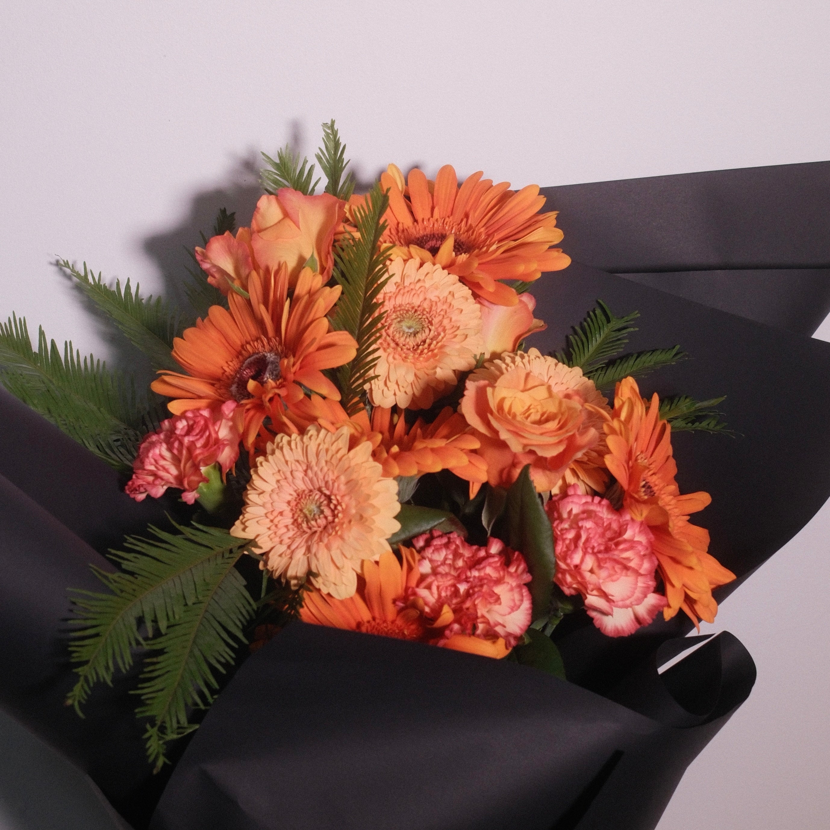 Elegant orange graduation bouquet by Hanaya Flora, a Sydney florist creating personalised graduation flowers for university ceremonies.