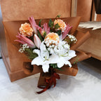 Hana-Akari bouquet of white and pink Oriental lilies, peach dahlias and Queen Anne's lace in caramel wrapping with a burgundy ribbon