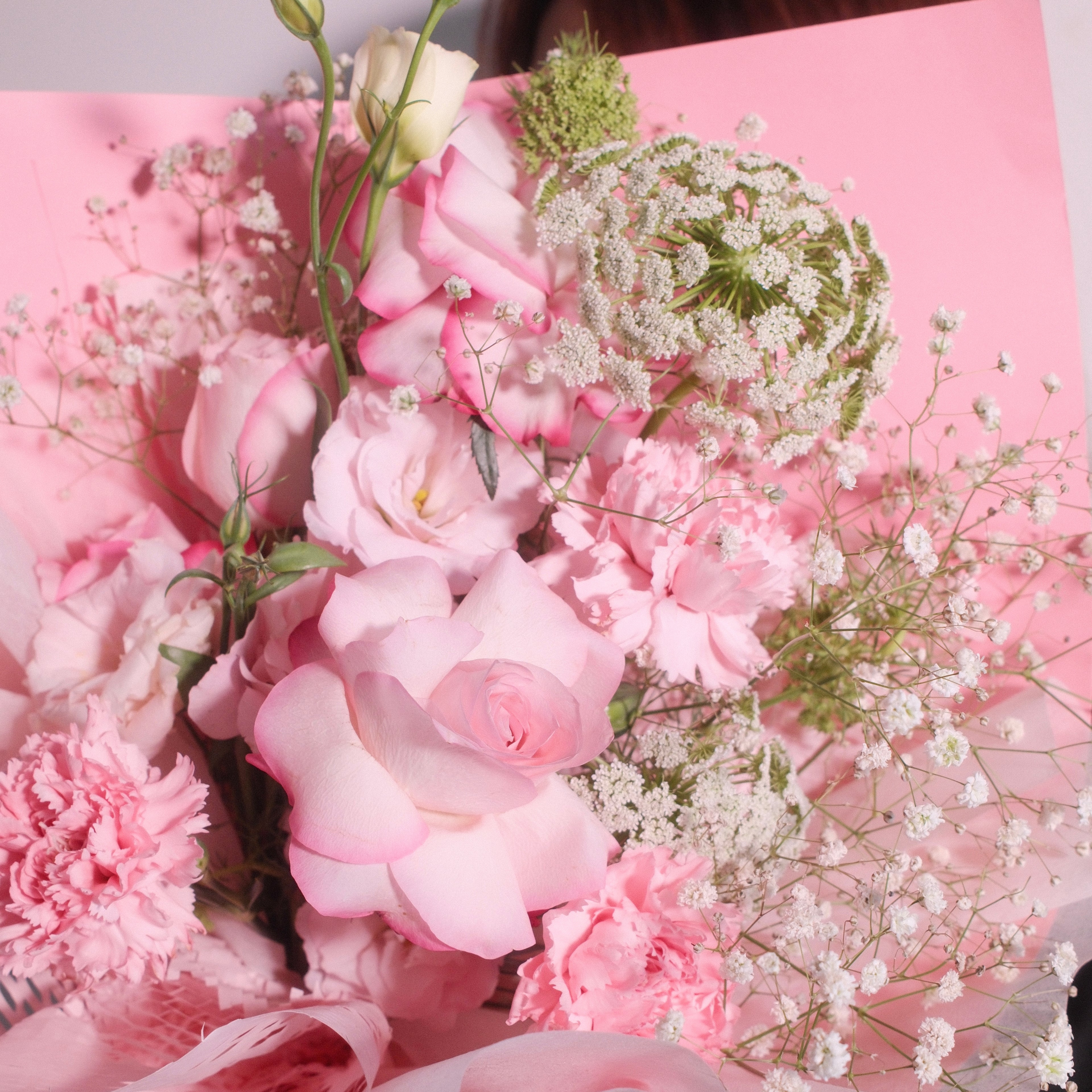 Close-up of Blossom Pride bouquet with pink roses, carnations and baby's breath