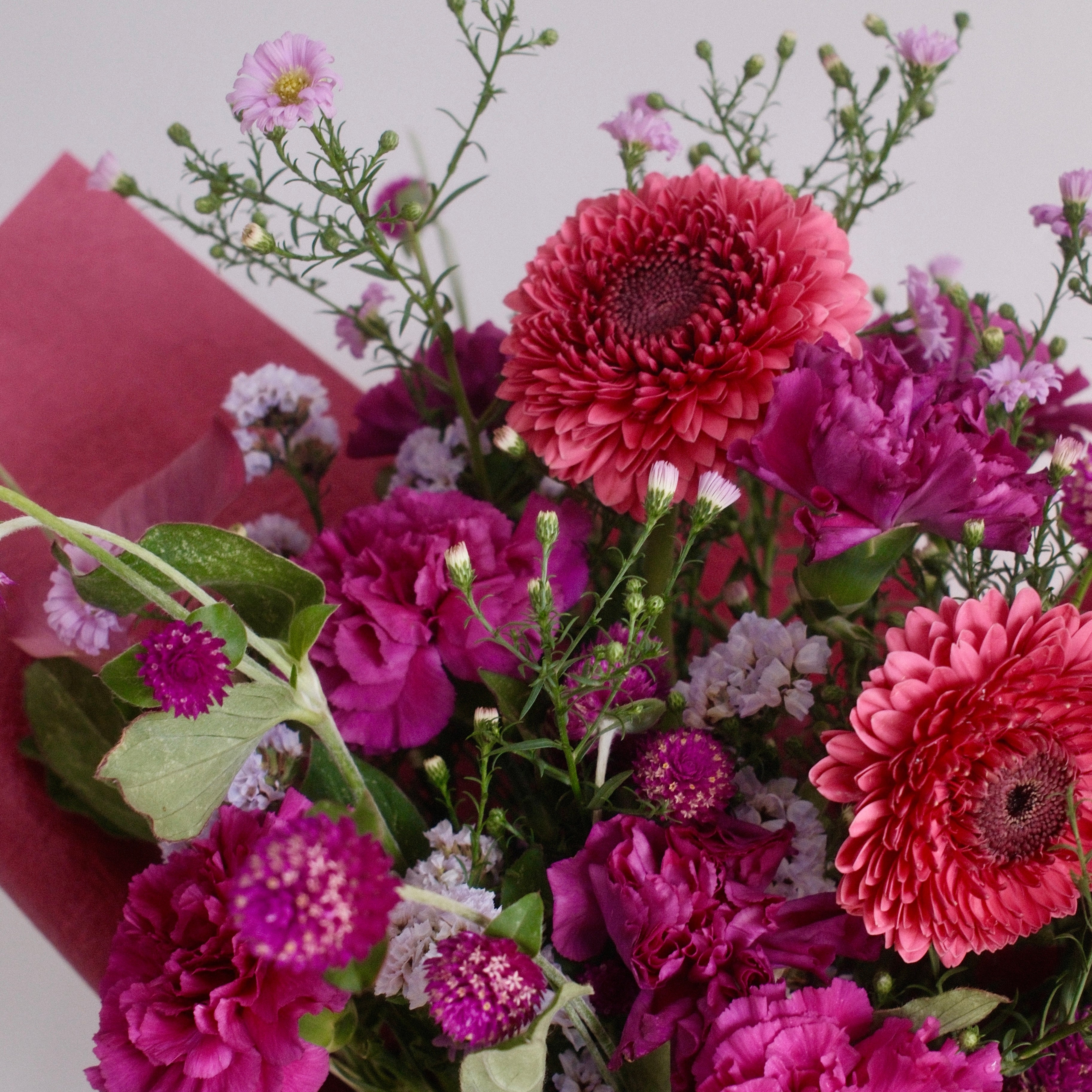 Close-up of Magenta Heart bouquet with magenta carnations and coral gerbera daisies