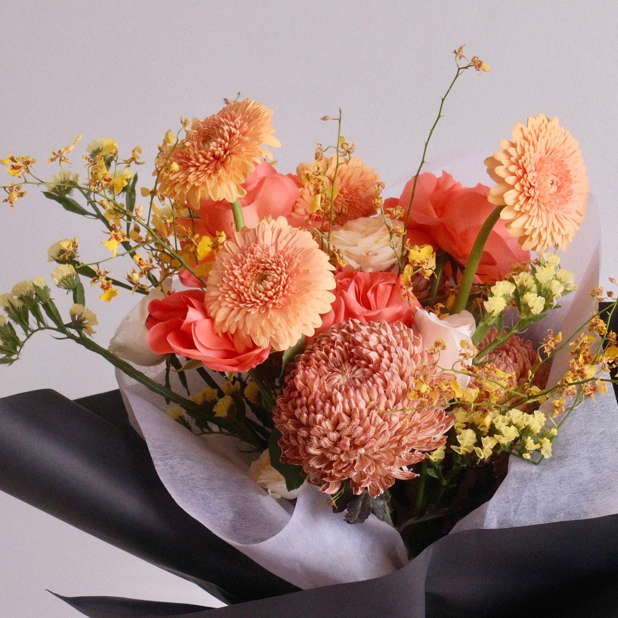 Close-up of Megumi Sunrise bouquet with peach and coral blooms