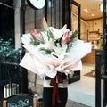 Person holding the Mirai Grace lily graduation bouquet outside Hanaya Flora florist in Sydney