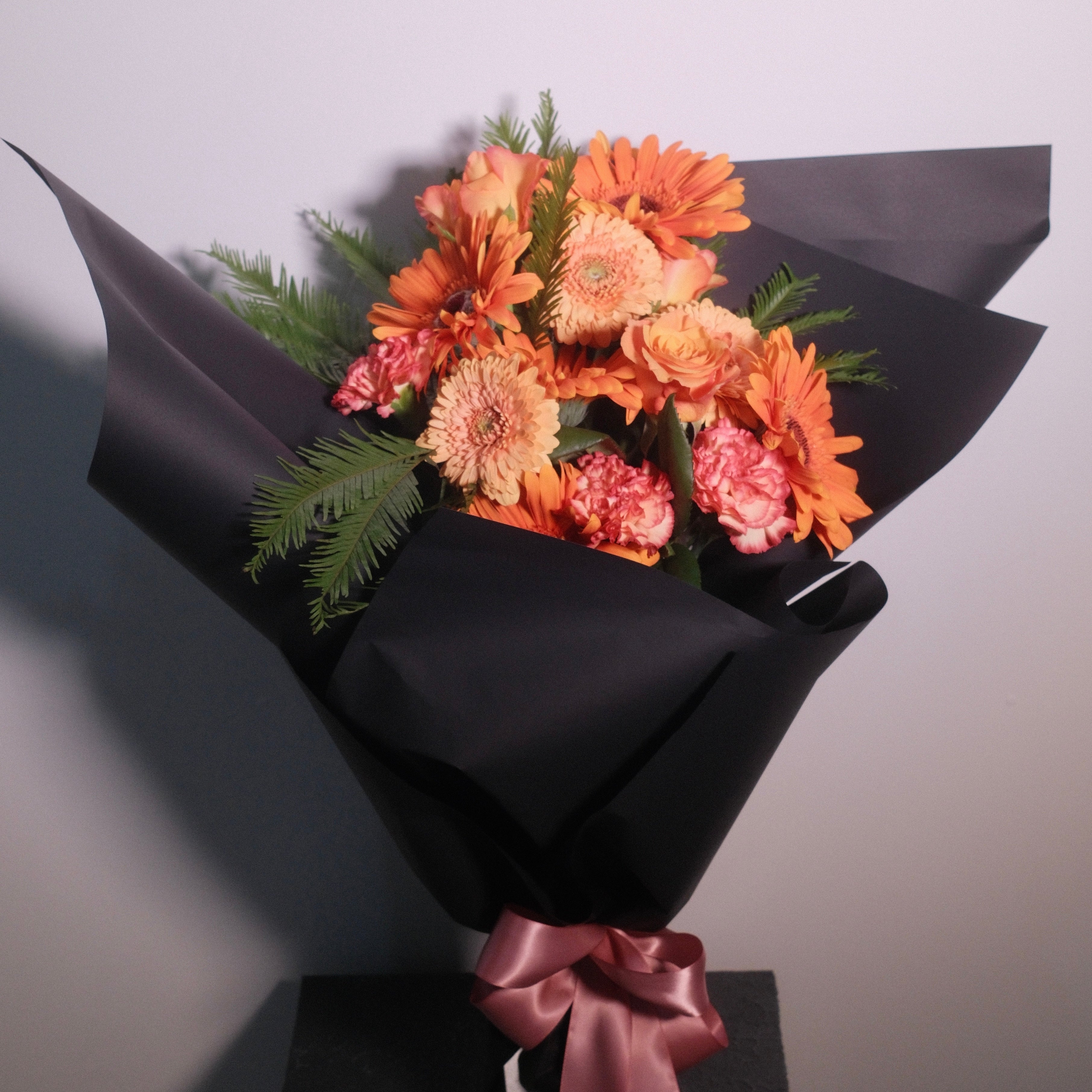 Elegant orange graduation bouquet by Hanaya Flora, a Sydney florist creating personalised graduation flowers for university ceremonies.