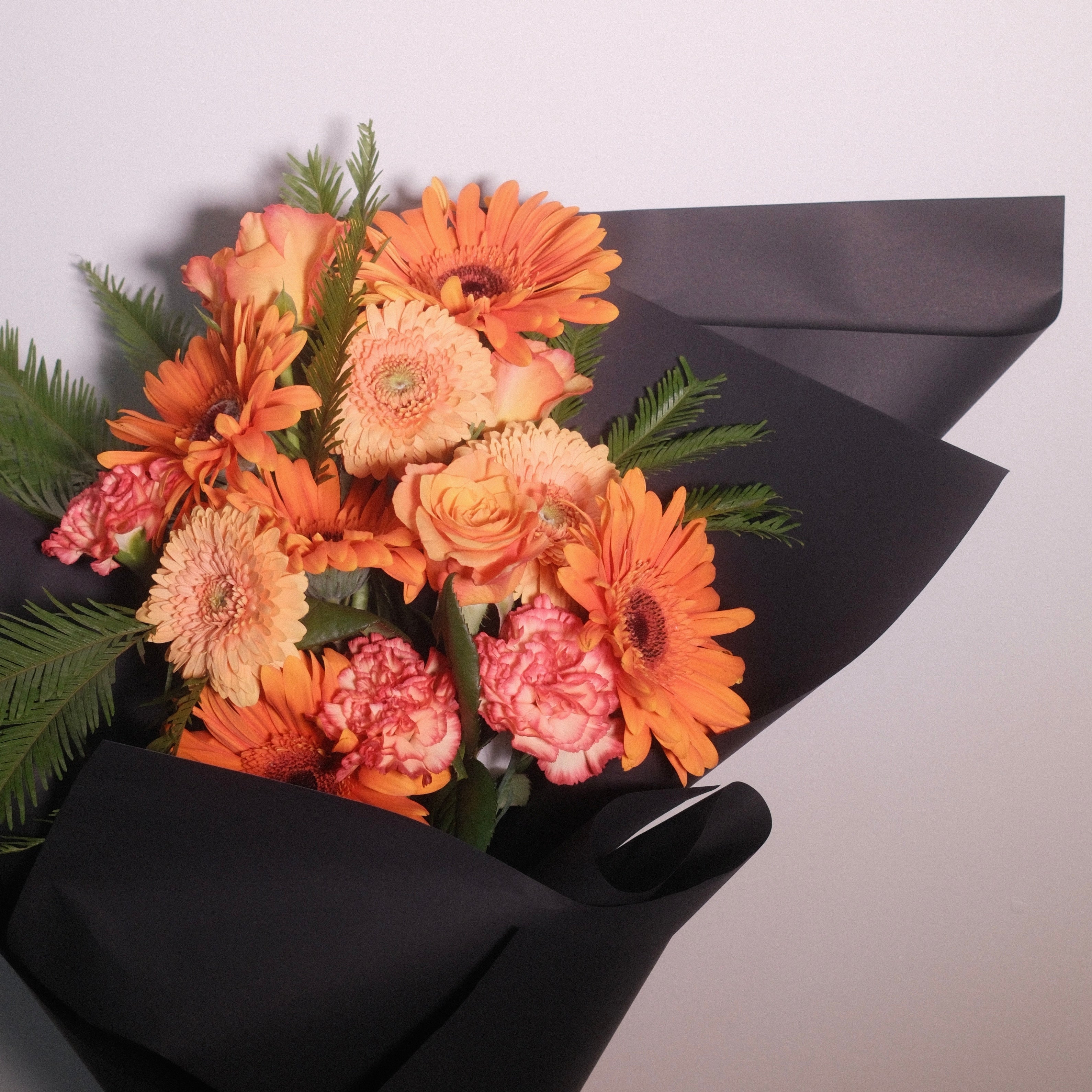 Elegant orange graduation bouquet by Hanaya Flora, a Sydney florist creating personalised graduation flowers for university ceremonies.