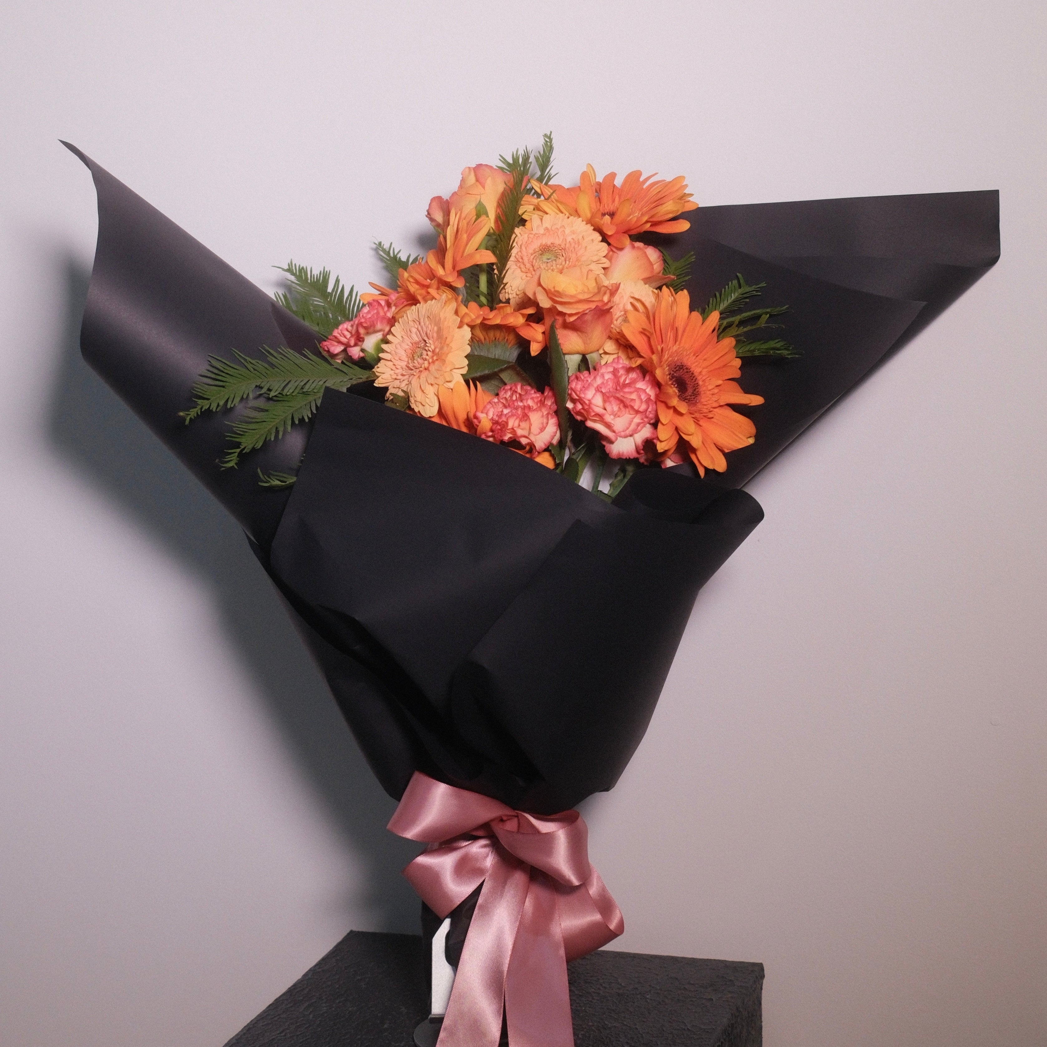 Elegant orange graduation flower bouquet by Hanaya Flora, a Sydney florist creating personalised graduation flowers for university ceremonies.