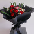 Bouquet of flowers with red carnation and chamomile, wrapped in premium black paper by Hanaya Flora, Surry Hills, Sydney. 