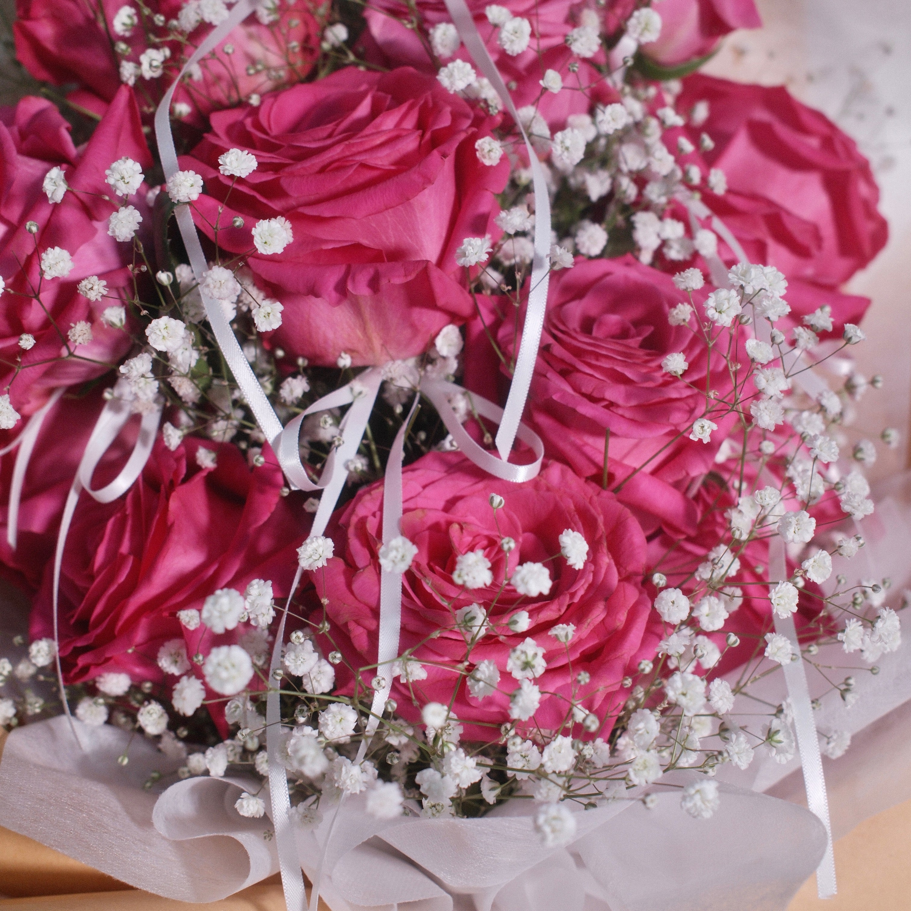 Close-up of Blush Promise bouquet with vivid pink roses and baby's breath