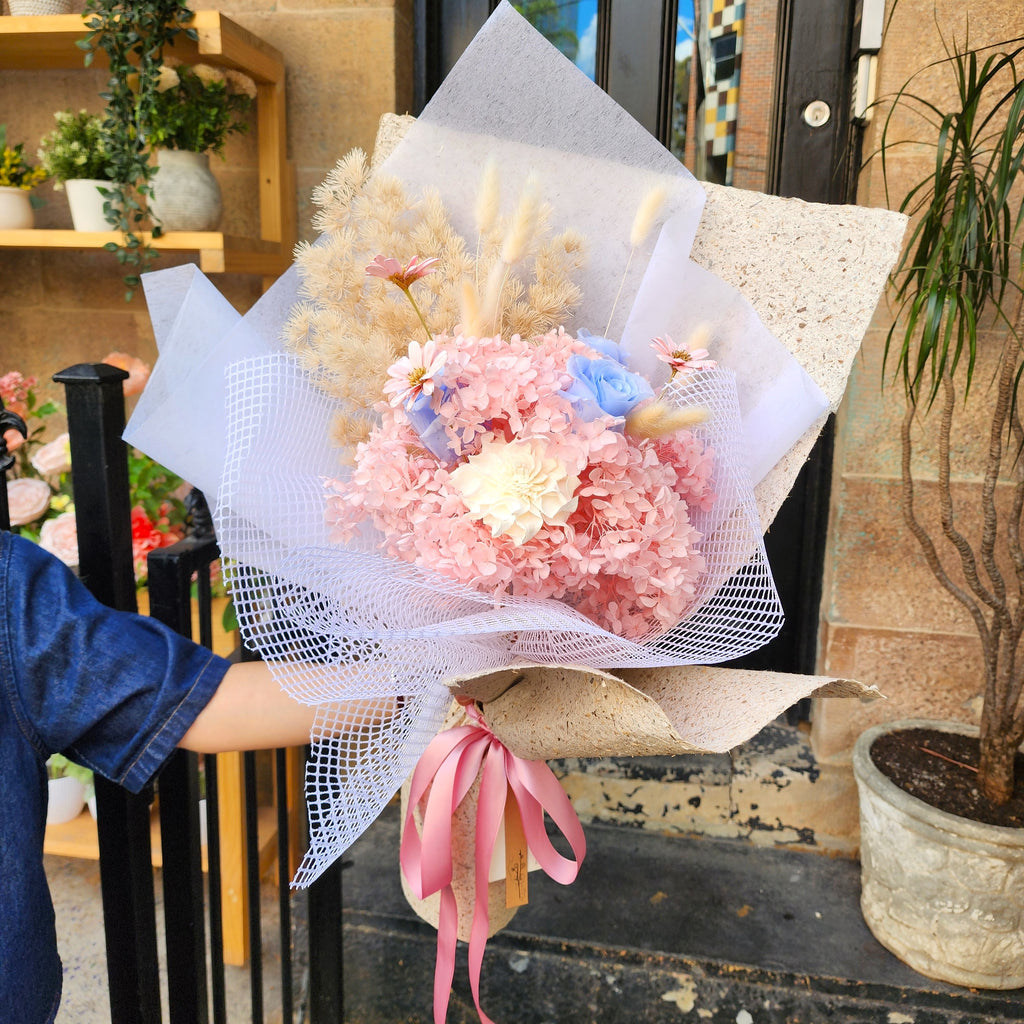 Sakura Dream preserved bouquet with pink hydrangea and blue roses held outside Hanaya Flora, Surry Hills