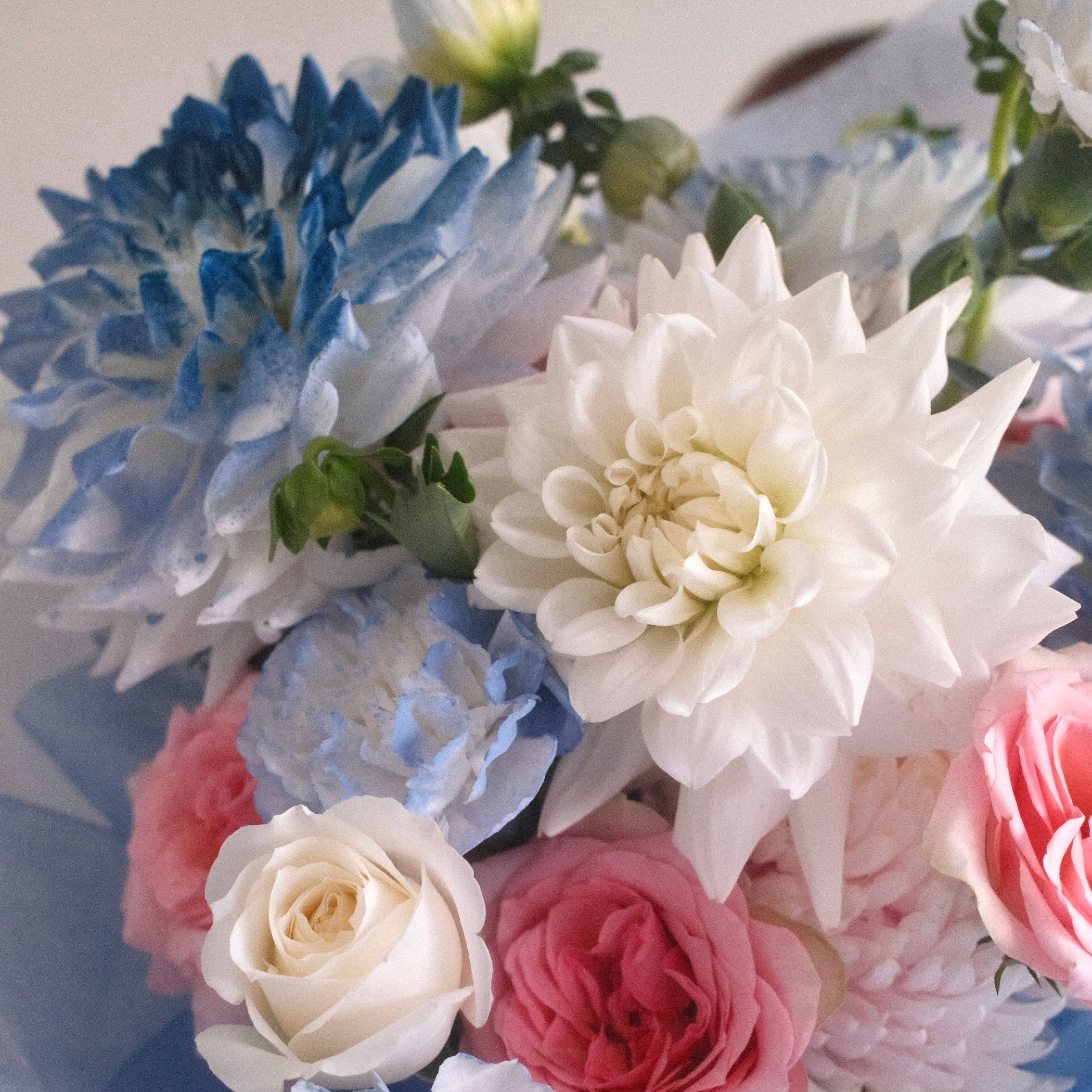 Close-up of Sky Muse bouquet with blue-white dahlias and pink garden roses