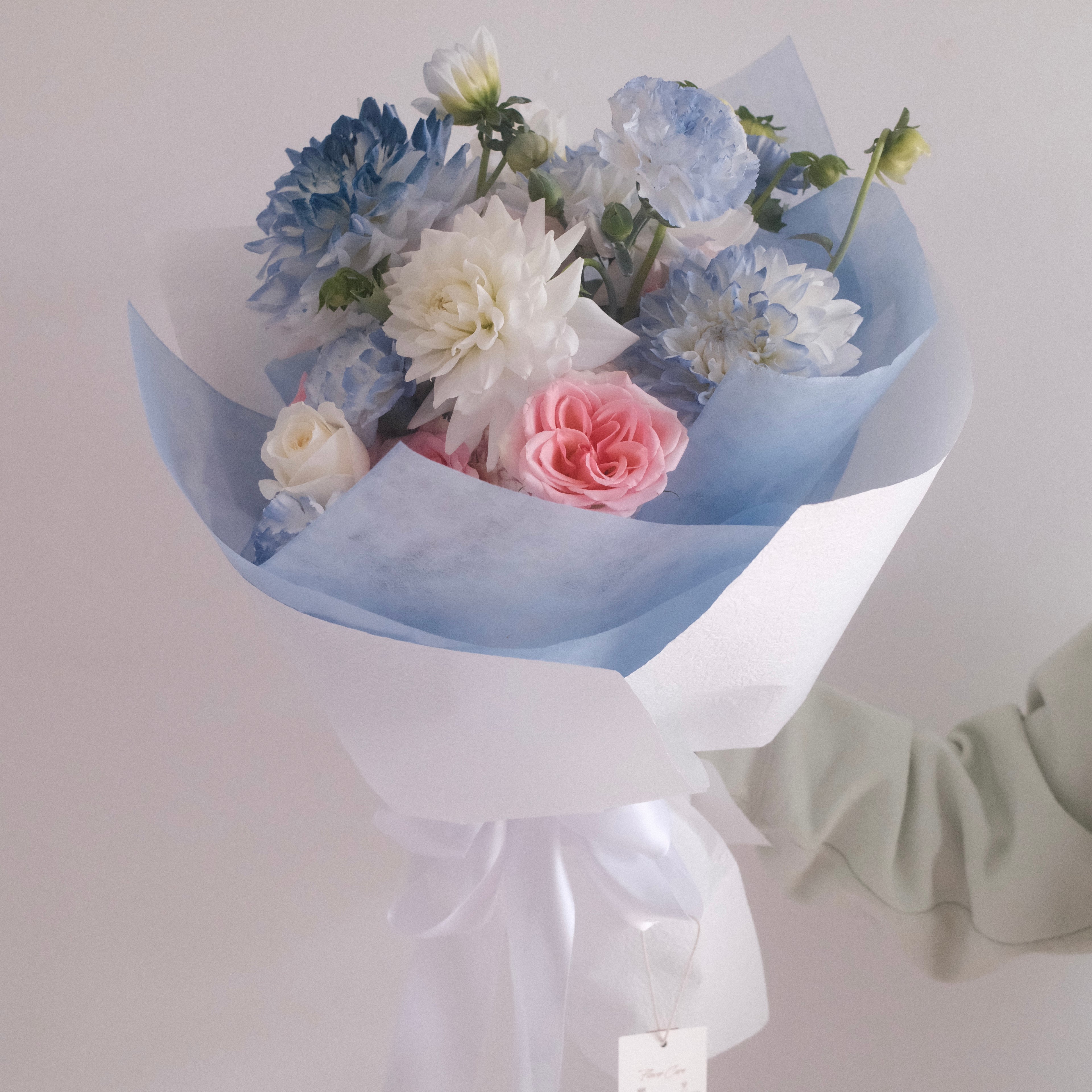 Florist holding the Sky Muse pastel bouquet, a gesture of love and appreciation