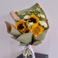 Bouquet of sunflowers and white flowers wrapped in green paper with a white ribbon, perfect for graduation flower gift delivered by Hanaya Flora, based in Sydney.