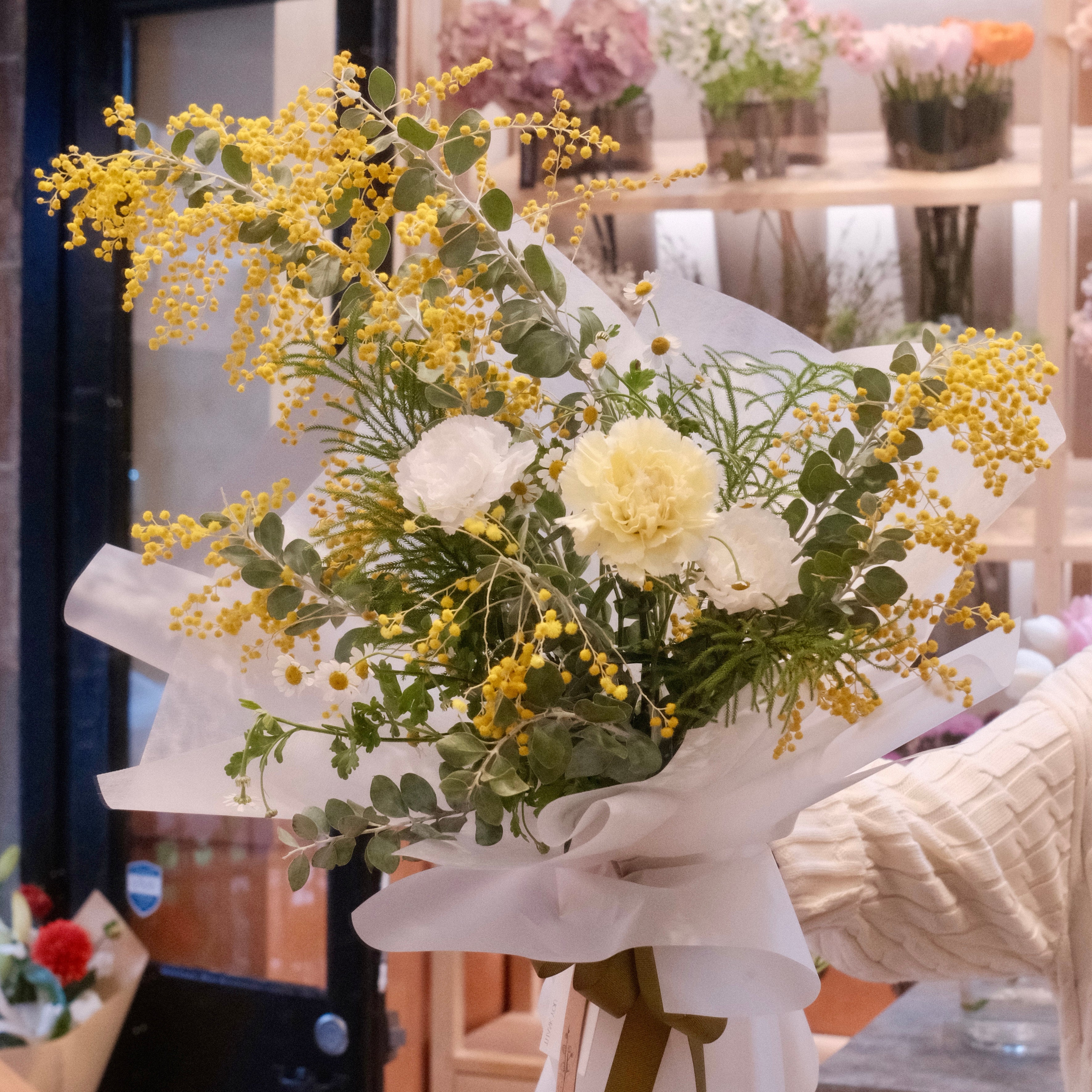 Florist holding the Tsukimi golden wattle bouquet in our Surry Hills flower shop