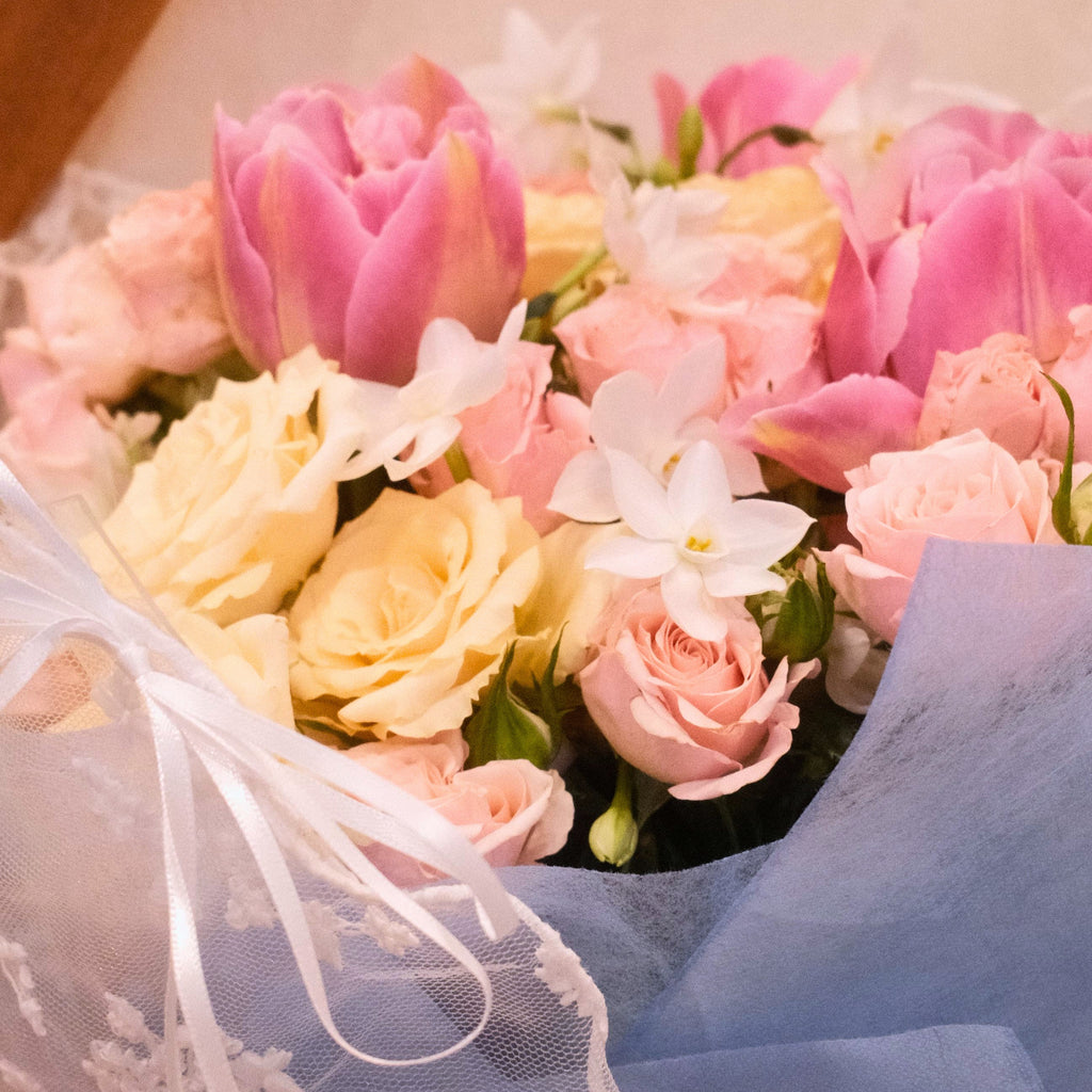 Bouquet of pink and white flowers such as tulip and roses that wrapped in lace wrapping designed by Hanaya Flora, Surry Hills, Sydney. 