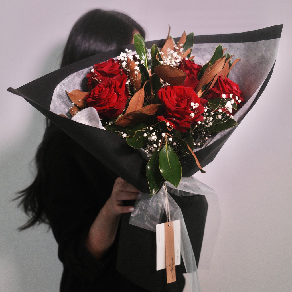 Florist holding the Velvet Amour red rose bouquet, a romantic gift, Sydney