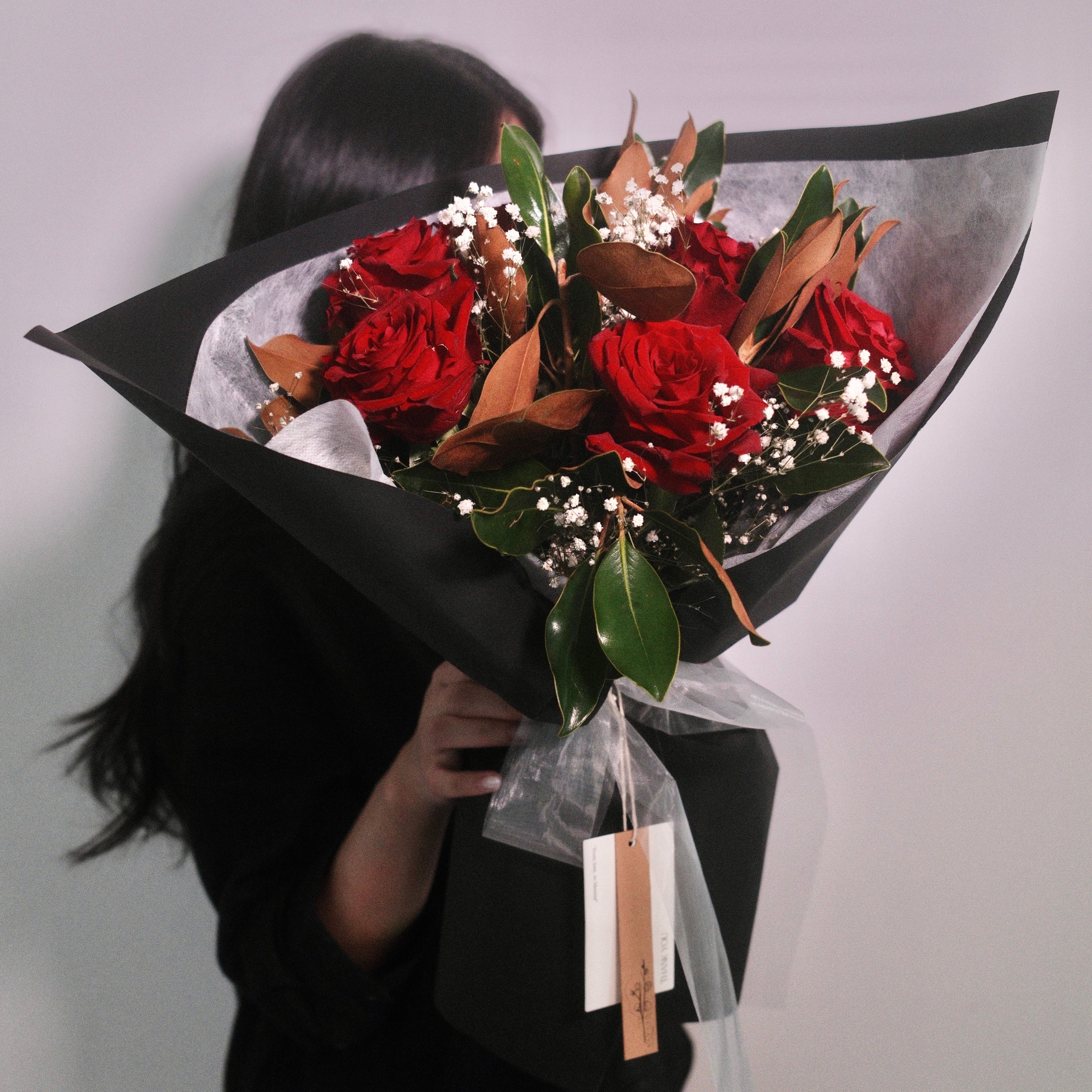 Florist holding the Velvet Amour red rose bouquet, a romantic gift, Sydney