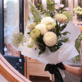Quiet Comfort bouquet of white chrysanthemums wrapped in white paper with a black ribbon, Hanaya Flora Surry Hills